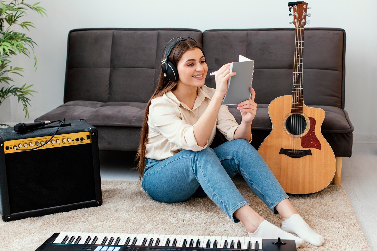 musico-femenino-sonriente-escribiendo-canciones-bloc-notas-junto-guitarra-acustica-teclado_23-2148890820